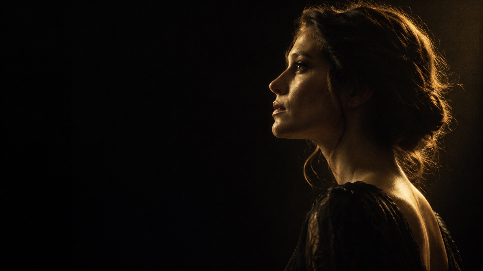 Portrait artistique de profil, éclairé par une lumière dorée.